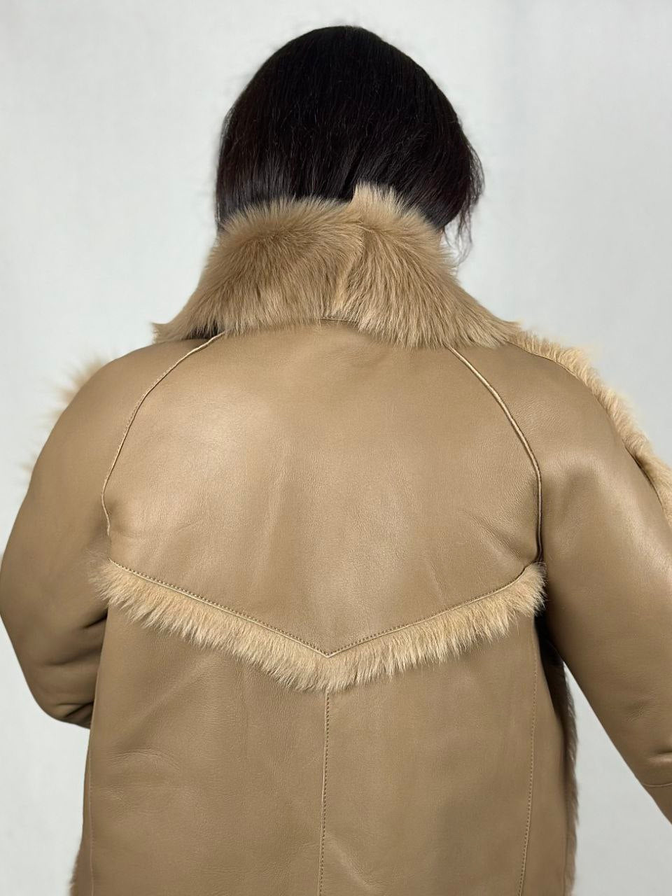 Beige women’s sheepskin coat with a fur collar